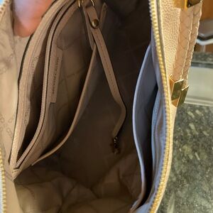 Blush pink shoulder bag is crafted from pebbled leather, can hold an iPad